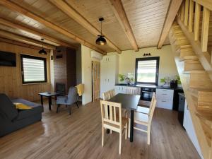 cocina y sala de estar con mesa y sillas en Grześny Domek en Zbiczno