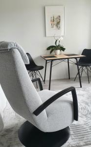 a grey chair in a living room with a table at Studio 12 floor, Puijo landscape, Free parking in Kuopio