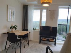 a living room with a table and a flat screen tv at Studio 12 floor, Puijo landscape, Free parking in Kuopio