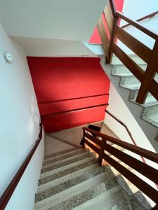un conjunto de escaleras en un edificio con techo rojo en Edifício Lorenzi - Suítes & Aparts, en Ubatuba