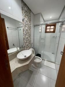 a bathroom with a sink and a toilet and a shower at Escalada Hospedagem Térreo in Mucugê +2 photos