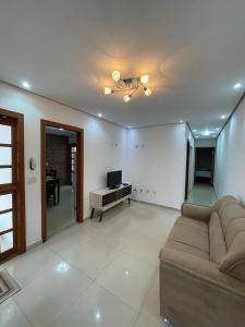a living room with a couch and a television at Escalada Hospedagem Térreo in Mucugê