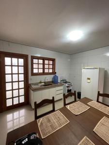 a kitchen with a refrigerator and a table and chairs at Escalada Hospedagem Térreo in Mucugê