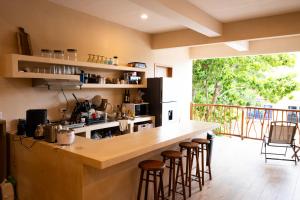 a kitchen with a bar with stools and a balcony at Yax Kiin Casa Boutique in Puerto Morelos