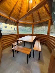 ein Zimmer mit Bänken und Tischen in einer Hütte in der Unterkunft Cabana AlexMid in Ranca