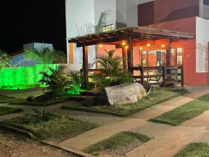 une maison avec des lumières vertes sur son côté dans l'établissement HOTEL LA SIERRA, à Bodoquena