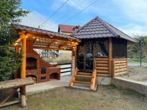 ein kleines Holzgebäude mit einem Herd im Hof in der Unterkunft Cabana AlexMid in Ranca