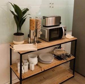 a kitchen shelf with a microwave and some dishes at Serviced Room im Herzen Berlin‘s in Berlin