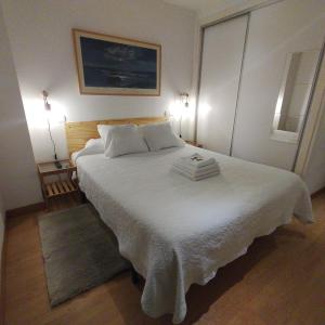 a bedroom with a large white bed with two pillows at Leon Riverside Flat in León