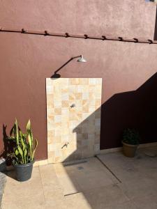 a lamp on the side of a building with plants at Edifício Lorenzi - Suítes & Aparts in Ubatuba +33 photos