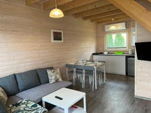 a living room with a couch and a table at Domki Słoneczka in Sarbinowo