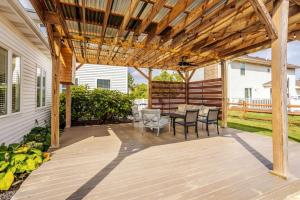 une terrasse avec une table et des chaises sous une pergola en bois dans l'établissement Sun-kissed Poolside 4B House with Fenced Backyard, à Hamilton