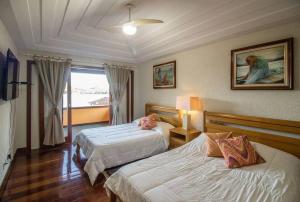 um quarto de hotel com duas camas e uma janela em Cinematográfica Mansão Pé na Areia da Ferradura com Treze Quartos Por Luxury Rentals em Búzios