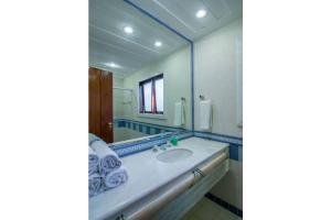 uma casa de banho com um lavatório e um espelho em Cinematográfica Mansão Pé na Areia da Ferradura com Treze Quartos Por Luxury Rentals em Búzios