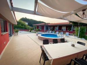 a patio with a table and chairs and a swimming pool at Turisalves- Ponte de Lima in Ponte de Lima