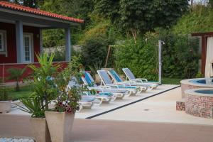 - une rangée de chaises longues bleues et blanches sur la terrasse dans l'établissement Turisalves- Ponte de Lima, à Ponte de Lima