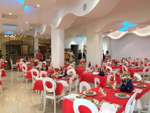 a banquet hall with red tables and white chairs at Hotel Gardenia in Bellaria-Igea Marina
