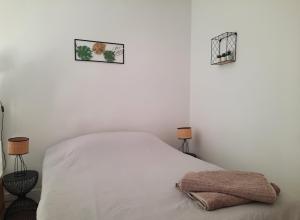 ein Schlafzimmer mit einem weißen Bett mit zwei Lampen in der Unterkunft Le studio d'en O, Au cœur de la haute ville de Pornic. in Pornic