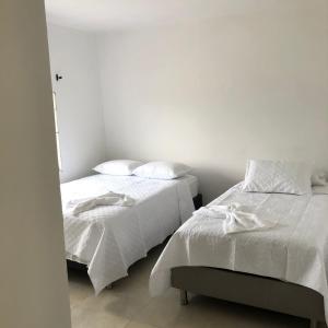 dos camas sentadas una al lado de la otra en una habitación en Hotel Samark Valledupar, en Valledupar