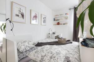 a white bedroom with a bed and a plant at New Studio Apartment Sun in Zagreb
