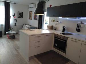 a kitchen with white cabinets and a stove top oven at New Studio Apartment Sun in Zagreb