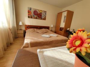 1 dormitorio con 2 camas y un jarrón con una flor en Musninkų apartment near Akropolis, en Vilna
