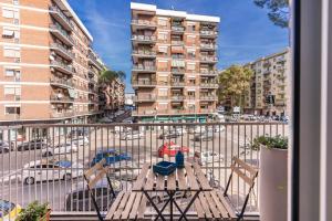 d'un balcon avec une table et des chaises dans une rue de la ville. dans l'établissement Stasera a casa da M.E., à Rome