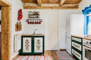 a kitchen with green cabinets and a white refrigerator at Lazar Guesthouse in Şiclod