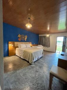 um quarto com uma cama grande e uma parede azul em Pousada Lençóis Eco Villa em Santo Amaro