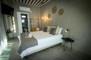 um quarto com uma grande cama branca e uma mesa em L'École Eco Resort 