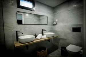 uma casa de banho com 2 lavatórios, um espelho e um WC em L'École Eco Resort 