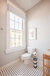 La salle de bains est pourvue de toilettes blanches et d'une fenêtre. dans l'établissement Relaxing, Boho Chic 2B 2Bath Downtown City View Condo, à Cincinnati