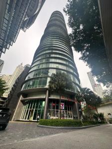 a tall building with a tree in front of it at Vortex Suites KLCC By Neptune in Kuala Lumpur