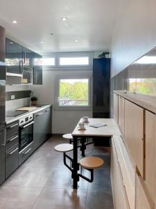 a kitchen with a table and two stools in it at Auteuil • 4 Chambres • Wifi • Métro à 400m in Rennes