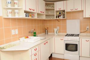 a kitchen with white cabinets and a sink and a stove at Chata Berešík in Terchová