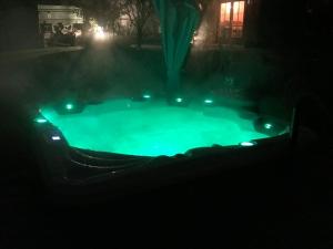 een klein zwembad met groene lichten in het donker bij Hochwertige Ferienwohnung im Bauernhaus in Freital