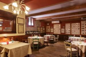 uma sala de jantar com mesas e cadeiras com toalhas de mesa brancas em LOCANDA LE 4 CIACOLE em Roverchiara