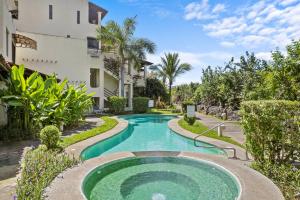 a swimming pool in front of a building at Beautiful beach front entire condo in Coco