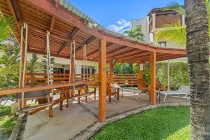a wooden pergola with tables and chairs under it at Beautiful beach front entire condo in Coco