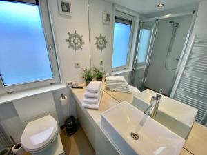 uma casa de banho com um lavatório, um WC e um espelho. em Het VaarHuis - Beachclub Sneek em Offingawier