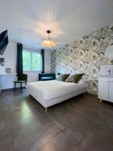 una camera da letto con un grande letto bianco e un muro in pietra di Auteuil • 4 Chambres • Wifi • Métro à 400m a Rennes