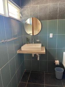 y baño con lavabo y espejo. en roca azul cabañas sa de cv, en Jocotepec