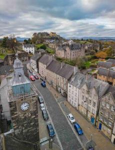 una città con torre dell'orologio e auto parcheggiate di Broad Street Stirling a Stirling