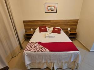 1 dormitorio con 1 cama con 2 almohadas rojas en HOTEL INDIANO, en Rio Bonito