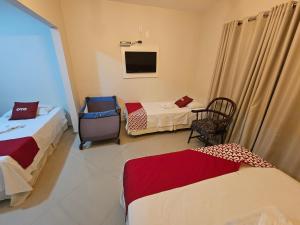 a hotel room with two beds and a tv at HOTEL INDIANO in Rio Bonito