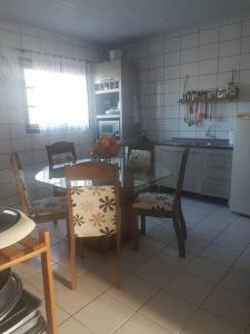 a kitchen with a table and two chairs and a table and a table and chairs at Um lugar para relaxar in Palhoça