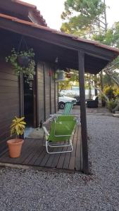 2 chaises vertes assises sur une terrasse couverte d'une maison dans l'établissement Um lugar para relaxar, à Palhoça