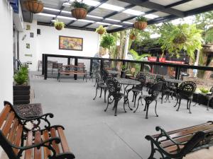 an outdoor patio with tables and chairs and tables and benches at Hotel Acqua Medellín in Medellín