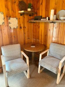 2 Stühle und ein Tisch in einem Zimmer in der Unterkunft Cabin 8 at Horse Creek Resort in Rapid City
