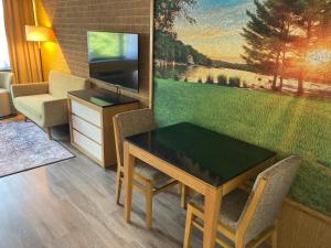 uma sala de estar com uma mesa e cadeiras e um quadro em The Lodge Luxury Resort At Lake Harmony em Lake Harmony